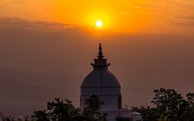 Schöne Landschaftsansicht des düsteren Sonnenaufgangs und der Weltfriedensstupa in Pokhara Nepal