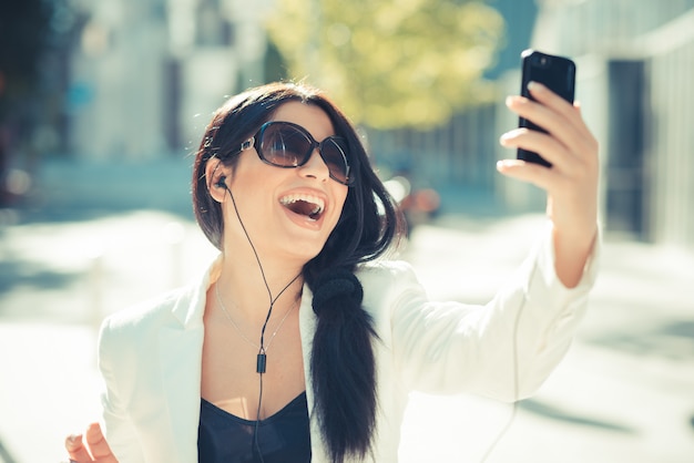 schöne lange schwarze Haare elegante Business-Frau mit Smartphone