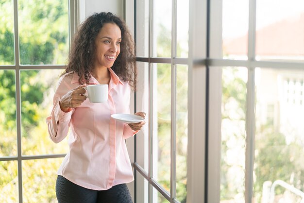 Schöne lateinische Frau, die morgens Kaffee trinkt