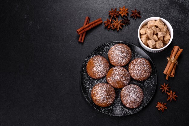 Schöne leckere Cupcakes mit Kakao und Rosinen auf schwarzem Betongrund Zeit zum Teetrinken