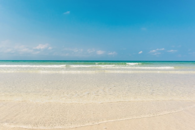 Schöne leichte Welle am flachen Strand mit blauem Himmel