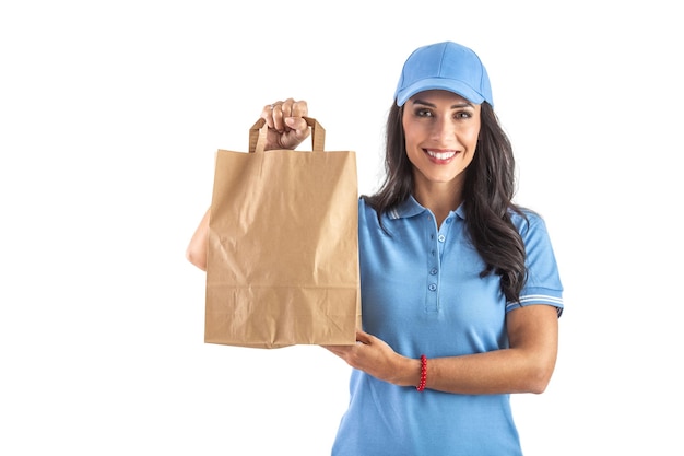 Schöne lieferfrau in einer uniform, die eine papiertüte zum mitnehmen hält und auf ihren kunden wartet isolierter hintergrund