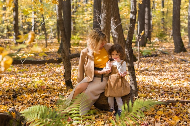 Schöne Lifestyle-Herbst-Foto-Mutter und Kind geht abends im Park, warmes Sonnenlicht.