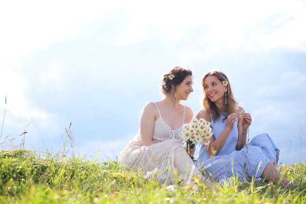 Schöne Mädchen an einem Sommertag, die in Sarafans auf dem Feld herumlaufen?