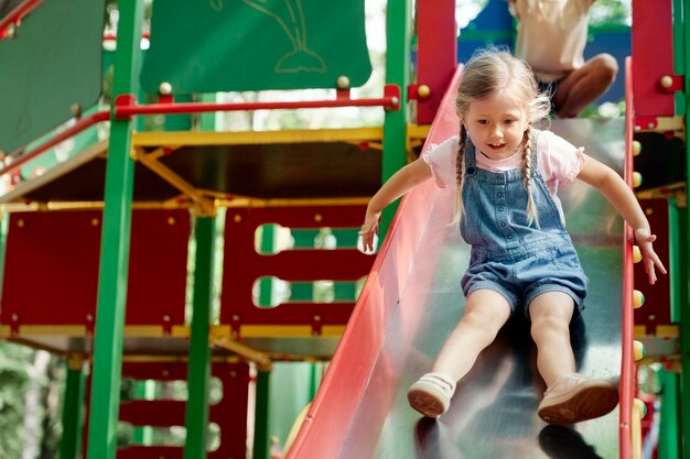 Schöne Mädchen haben Spaß auf dem Spielplatz an einem sonnigen Tag