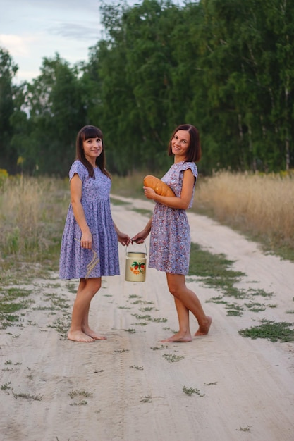 Schöne Mädchen in einem Feld mit Weizen Milch und Brot Friedenszeit Glück Liebe Zwei Schwestern Freundinnen