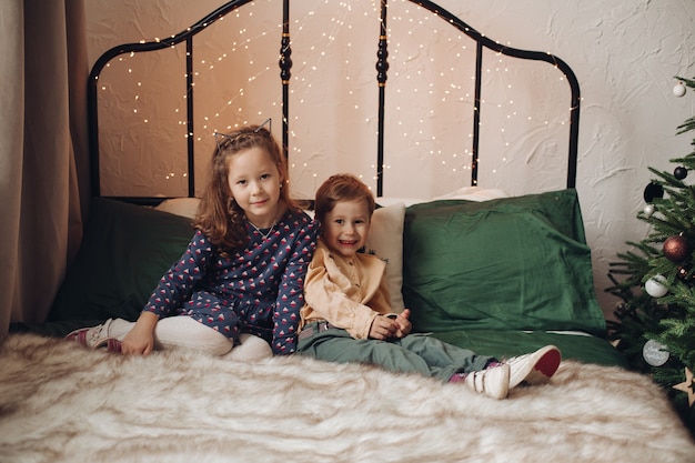 Schöne Mädchen sitzen auf gemütlichem Bett