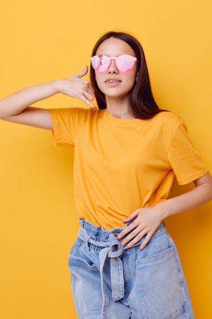 Schöne Mädchenmode in gelben T-Shirt-Denim-Shorts isolierter Hintergrund