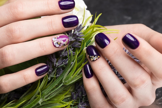 Schöne Maniküre mit Blumen auf weibliche Finger geschossen. Nageldesign. Nahaufnahme. Bild im Studio auf weißem Hintergrund.