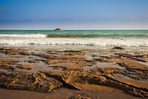 Schöne Meereslandschaft mit Silhouette von Wanderern an einem Sandstrand im Sommer
