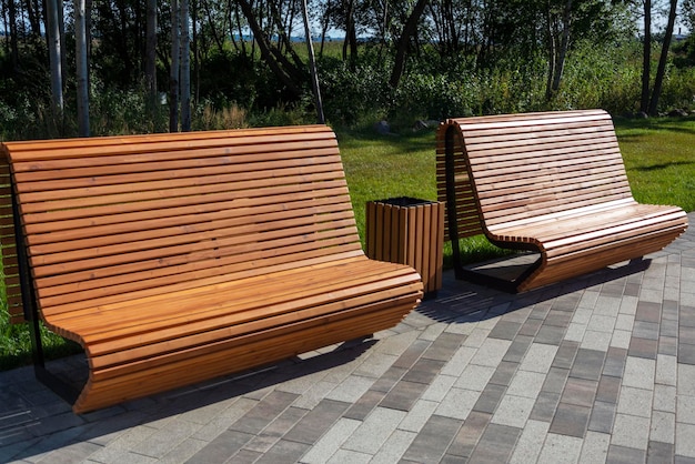 Schöne, moderne, elegante Holzbänke im Park für Freizeitaktivitäten im Freien