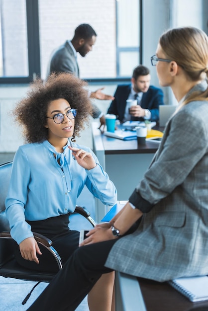 schöne multiethnische Geschäftsfrauen sprechen im Büro