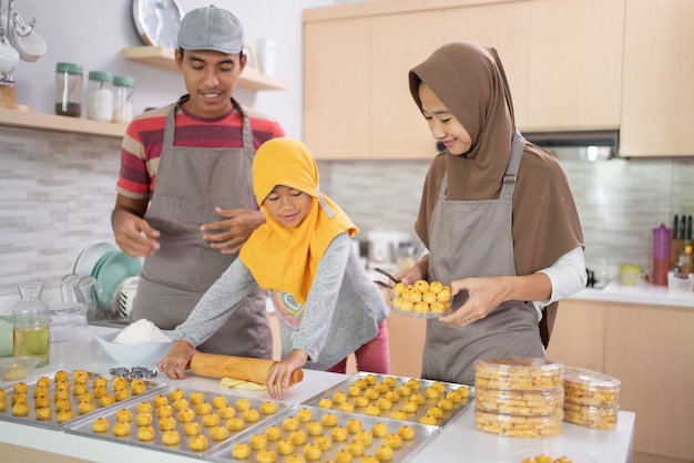 Schöne muslimische Familie, die zu Hause zusammen Nastar-Ananaskuchen der indonesischen Tradition macht