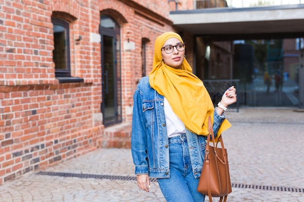 Schöne muslimische Frau, die gelben Hijab trägt