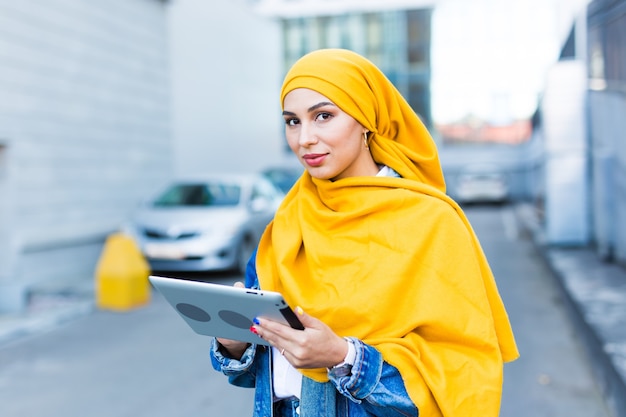 Schöne muslimische Frau mit Tablette