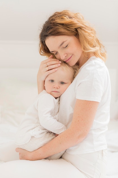 Foto schöne mutter, die ihr baby hält