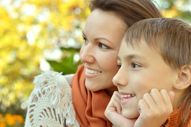 Schöne Mutter mit Sohn im Herbstpark