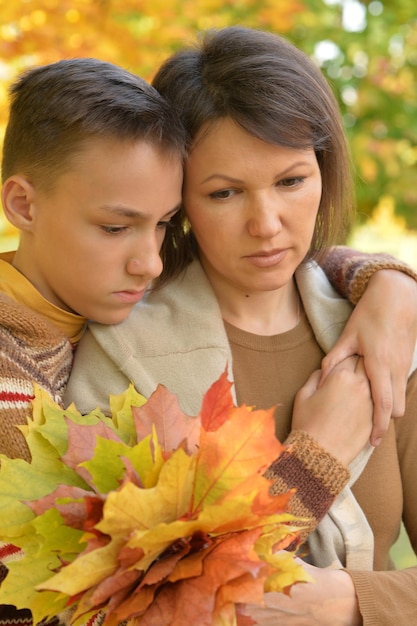 Schöne Mutter mit Sohn im Herbstpark