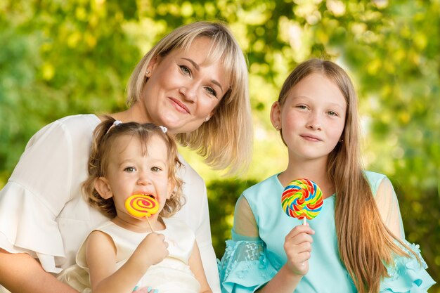 Schöne Mutter mit Töchtern draußen im Sommer im Park