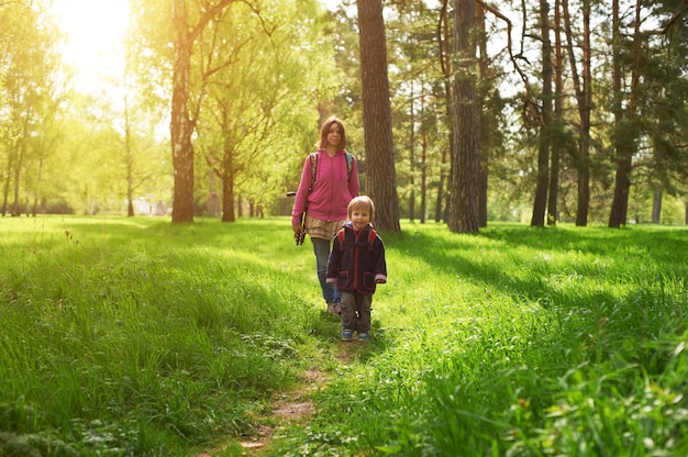 Schöne Mutter und ihr süßer Sohn, die im Park gehen