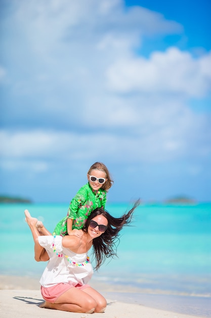 Schöne Mutter und Tochter am karibischen Strand Sommerferien genießend.