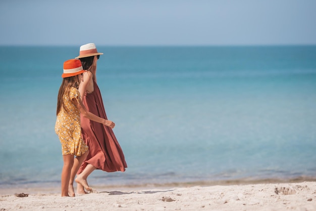 Schöne Mutter und Tochter am Strand, die Sommerferien genießen