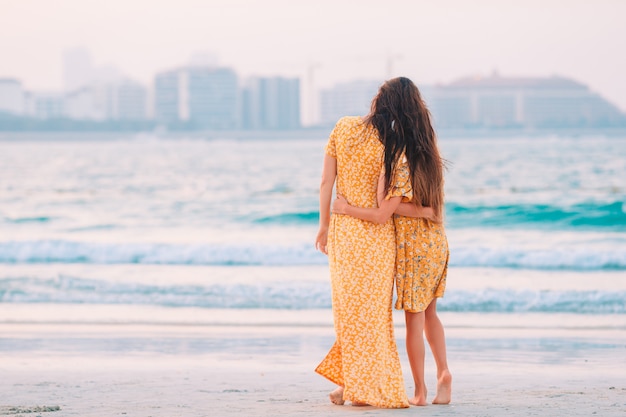 Schöne Mutter und Tochter am Strand genießen Sommerferien.