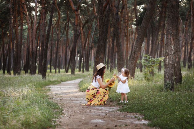 Schöne Mutter und Tochter auf einem Spaziergang im Wald