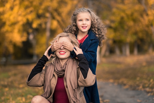 Schöne mutter und tochter im bunten herbst draußen