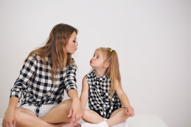 Schöne Mutter und Tochter mit passenden Hemden