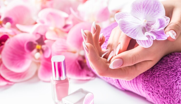 Schöne Nagelmaniküre mit Dekoration aus rosa Orchidee.