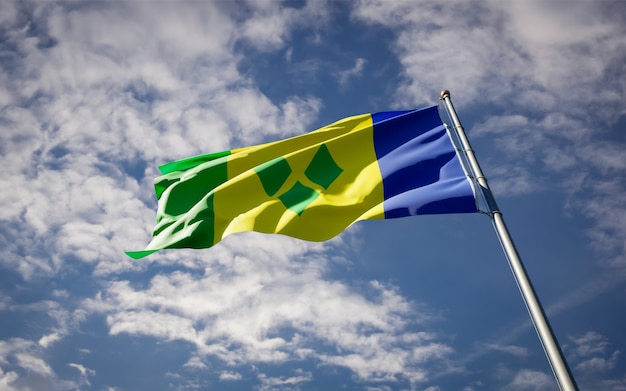 Schöne Nationalstaatsflagge der Grenadinen, die auf blauem Himmel flattern