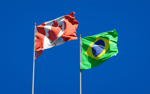 Schöne Nationalstaatsflaggen von Brasilien und Kanada zusammen auf blauem Himmel