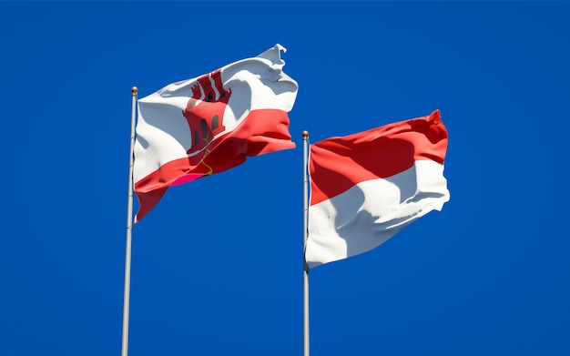 Schöne Nationalstaatsflaggen von Gibraltar und Indonesien zusammen auf blauem Himmel