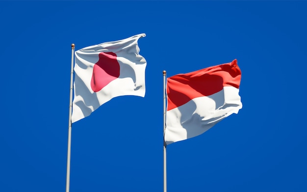 Schöne Nationalstaatsflaggen von Japan und von Indonesien zusammen auf blauem Himmel