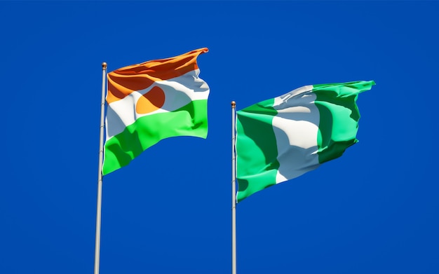 Schöne Nationalstaatsflaggen von Niger und Nigeria zusammen auf blauem Himmel