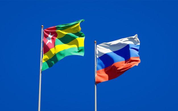 Schöne Nationalstaatsflaggen von Togo und Russland zusammen auf blauem Himmel. 3D-Grafik