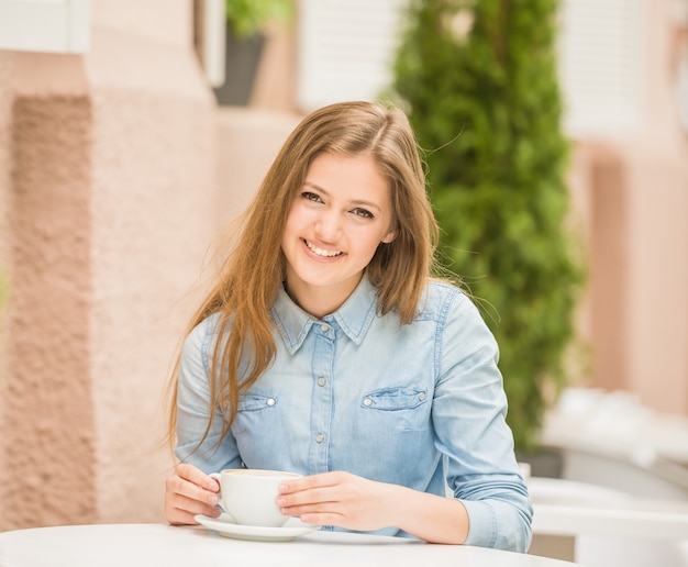 Schöne nette Frau, die im Sommercafé sitzt.