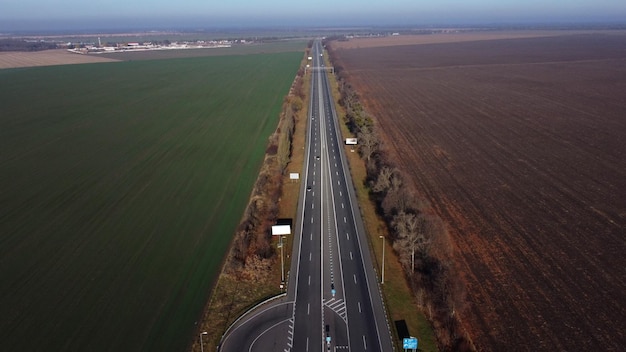 Schöne Panoramalandschaft, schwarz gepflasterte Autobahn mit weißen Markierungen, viele vorbeifahrende Autos groß