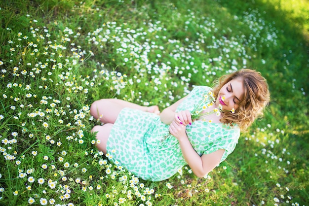 Schöne positive junge Frau in einem grünen Kleid