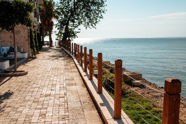 Schöne Promenade der Stadt Side Zaun mit Holzpfosten, an denen Palmen wachsen. Fünf-Sterne-Konzept.