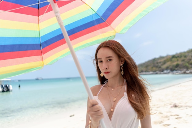 Schöne Reisende Frau Asiens mit Regenschirm auf dem Strandkonzept Tourismus im Sommerurlaub