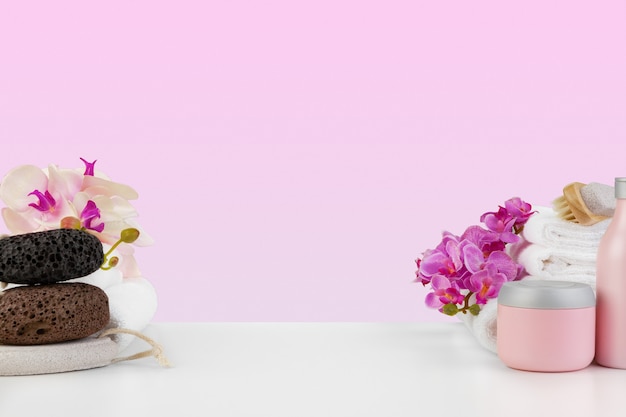 Schöne rosa Blumen und weiße Handtücher auf rosa Hintergrund