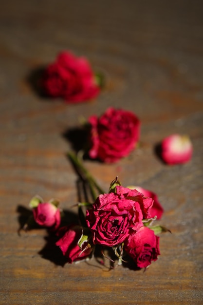 Schöne rosa getrocknete Rosen auf altem hölzernem Hintergrund