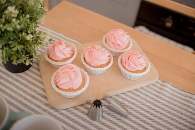 Schöne rosa Kuchen stehen auf einem Ständer auf dem Tisch