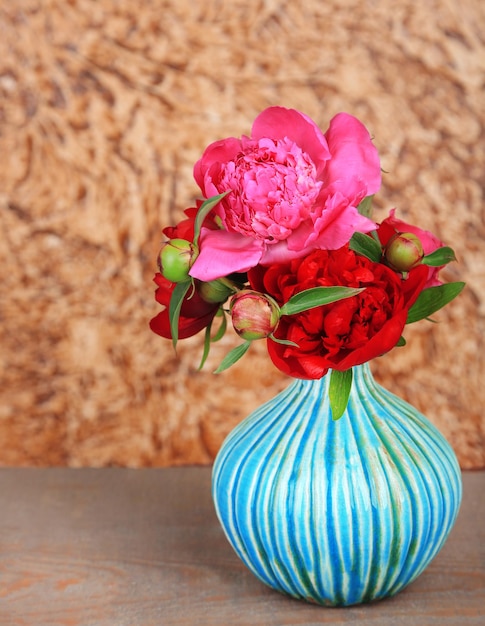 Schöne rosa Pfingstrosen auf braunem Wandhintergrund