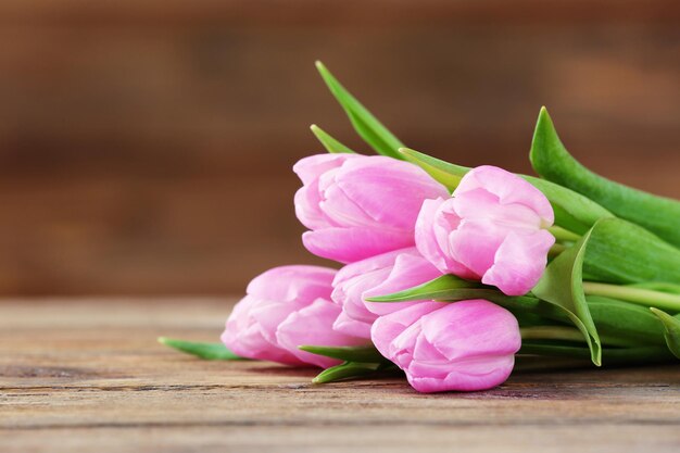 Schöne rosa Tulpen auf Holzhintergrund