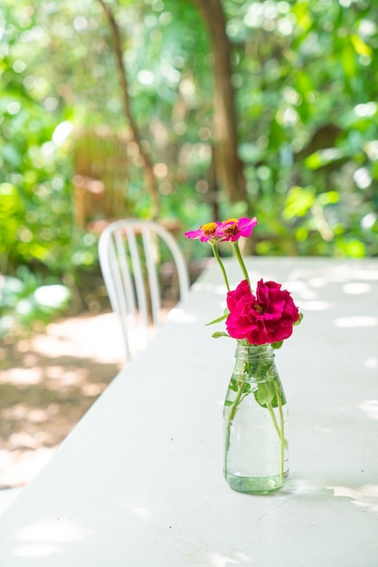 Schöne Rosenblume in Vase, die auf dem Tisch im Café-Restaurant dekoriert ist