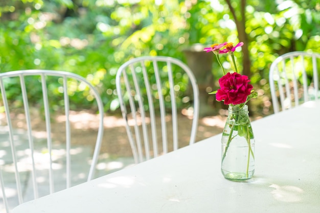 Schöne Rosenblume in Vase, die auf dem Tisch im Café-Restaurant dekoriert ist