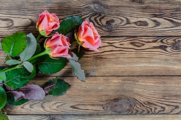 Schöne Rosenblumen auf rustikalem Holztisch